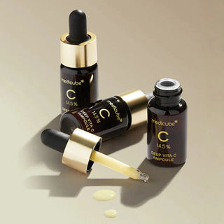 Trois flacons Medicube Deep Vita C Ampoule 2.0 couches avec pipette ouverte et gouttes de serum jaune