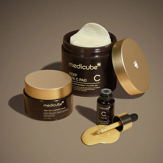 Gamme Medicube Deep Vita C avec pot de pads, capsule cream et ampoule pipette au serum dore