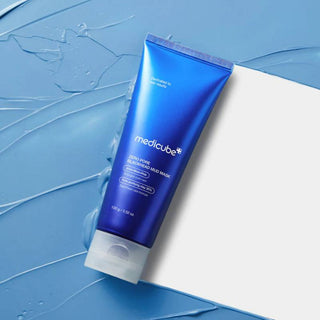 Tube bleu Medicube Zero Pore Mud Mask pose en diagonale sur fond de texture argile bleue