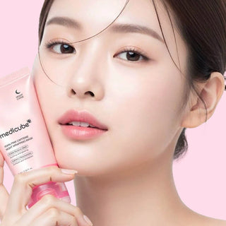 Femme tenant le tube rose Medicube PDRN Pink Caffeine Night Wrapping Mask contre sa joue sur fond rose