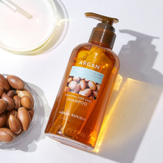 Nature Republic Argan Shampoo - flacon pompe ambre avec noix d'argan et pipette sur fond blanc lumineux