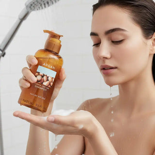 Nature Republic Argan Shampoo - mannequin sous la douche versant le shampoing ambre dans sa main