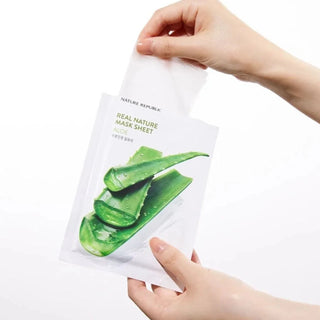 Deux mains ouvrant le sachet Nature Republic Real Nature Mask Sheet Aloe Vera sur fond blanc