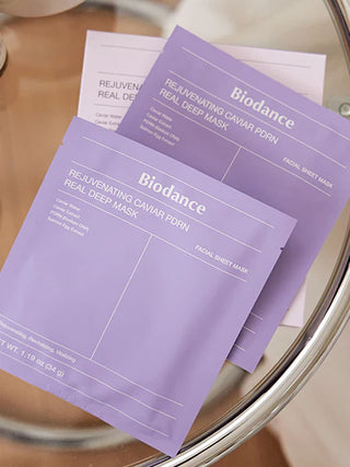 Sachets individuels BIODANCE Caviar PDRN Real Deep Mask empiles sur une table en verre