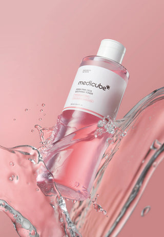 Medicube PDRN Pink Cica Soothing Toner eclabousse d'eau sur fond rose pastel