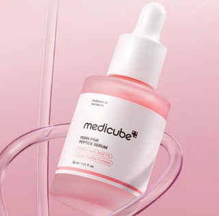 Medicube PDRN Pink Peptide Serum pose dans un entonnoir en verre transparent sur fond rose