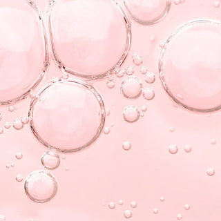 Bulles transparentes sur fond rose, evoquant la texture legere du serum ANUA Peach 77