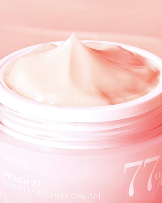 Gros plan texture onctueuse en pointe dans le pot ouvert ANUA Peach 77 Niacin Enriched Cream