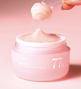 Texture cremeuse rose pale de la creme ANUA Peach 77 prelevee a la spatule depuis le pot ouvert
