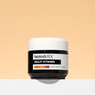 Heimish RX Multi Vitamin Dark Spot Cream pot noir ferme sur fond peche pastel