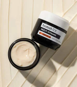 Heimish RX Dark Spot Cream pot ouvert avec texture creme beige rosee, vue plongeante sur bois clair