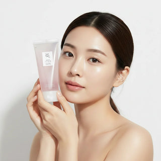 Modele au teint lumineux posant avec le tube Beauty of Joseon Red Bean Water Gel pres du visage