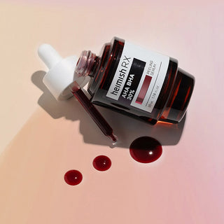 Heimish RX AHA BHA Peeling Serum flacon renverse avec pipette et gouttes rouge fonce sur fond rose