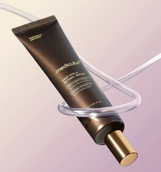 Tube Medicube Deep Vita A Retinol Serum en suspension avec fil transparent sur fond rose degrade