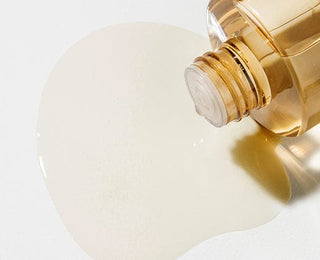 Texture liquide transparente du SKIN1004 Centella Toning Toner versee depuis le flacon dore
