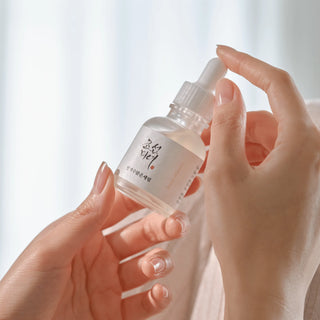 Mains tenant le flacon Beauty of Joseon Glow Deep Serum Rice, lumiere douce naturelle