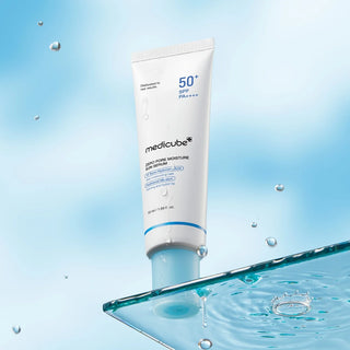 Tube MEDICUBE Zero Pore Moisture Sun Serum flottant au-dessus d'une surface d'eau avec eclaboussures
