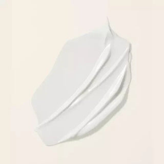 Touche de creme blanche lisse sur fond beige rosé, texture apres-shampooing Boucleme Seal + Shield