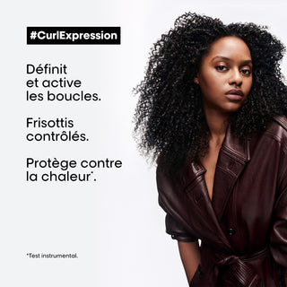 Femme aux cheveux boucles crepus noirs en veste cuir bordeaux - L'Oreal Professionnel Curl Expression