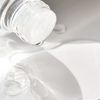 Isntree Hyaluronic Acid Toner - lotion versee du flacon transparent avec bulles sur fond blanc