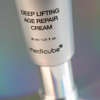 Gros plan bas du tube Medicube Deep Lifting Cream 30ml, inscription et logo sur fond irise