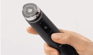 MEDICUBE AGE-R Booster Pro noir tenu en main, vue sur la tete et l'ecran digital