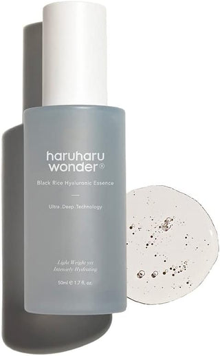 Flacon Haruharu Wonder Black Rice Essence incline avec texture gel transparente parsemee de particules