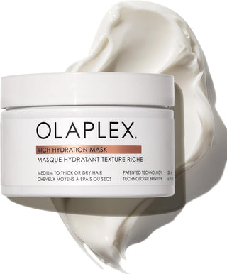 Olaplex Rich Hydration Mask pot blanc ouvert avec texture creme onctueuse blanche etalee en arriere-plan