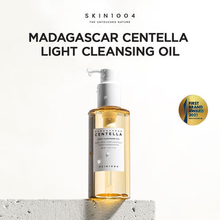 SKIN1004 Centella Light Cleansing Oil sur socle beton - flacon pompe avec gouttelettes et badge 2021