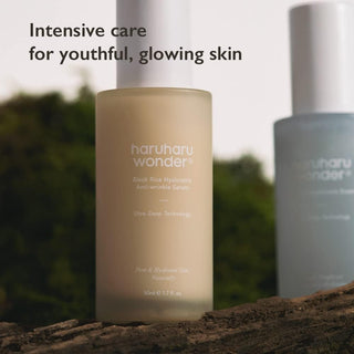 Haruharu Wonder Black Rice Hyaluronic Serum et Essence poses sur une branche avec fond de verdure naturelle