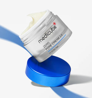 Pot Medicube Zero Pore Cream 2.0 ouvert en equilibre sur son couvercle bleu, texture creme visible