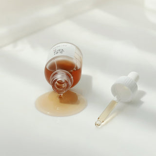 Beauty of Joseon Revive Serum Ginseng Snail Mucin - flacon renverse avec serum ambre coule sur surface