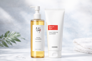 Beauty of Joseon huile nettoyante et COSRX nettoyant doux sur comptoir marbre avec feuille verte