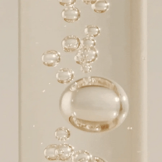 Gouttes de serum transparent deposees par une pipette en verre sur fond blanc, texture SKIN1004 Centella Ampoule