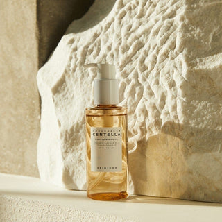 Flacon pompe SKIN1004 Centella Light Cleansing Oil devant pierre naturelle beige texturee