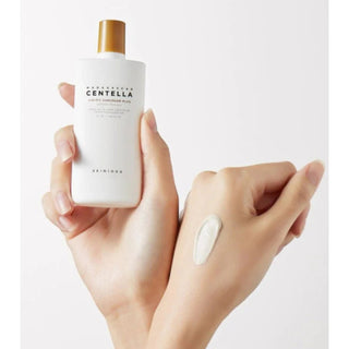 Skin1004 Madagascar Centella Sun Cream SPF50+ - main tenant le flacon avec swatch blanc sur le dos