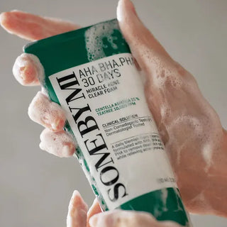 Mains moussantes tenant le tube vert SOME BY MI AHA BHA PHA 30 Days Miracle Cleanser en utilisation
