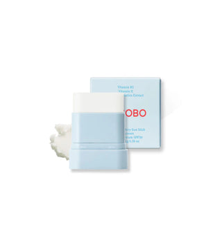 Stick solaire TOCOBO bleu clair sorti de son tube avec swatch de texture blanche et boîte SPF50 en arrière-plan